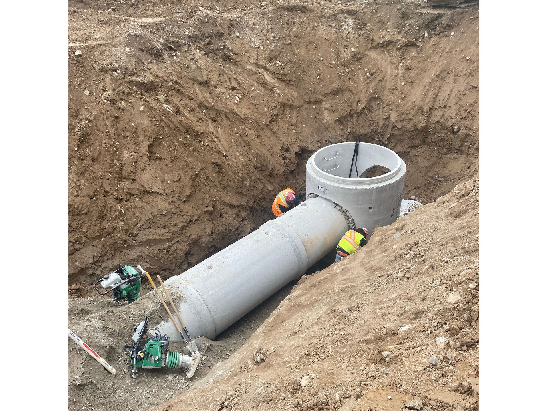 A large pipe is being installed in a hole in the ground.