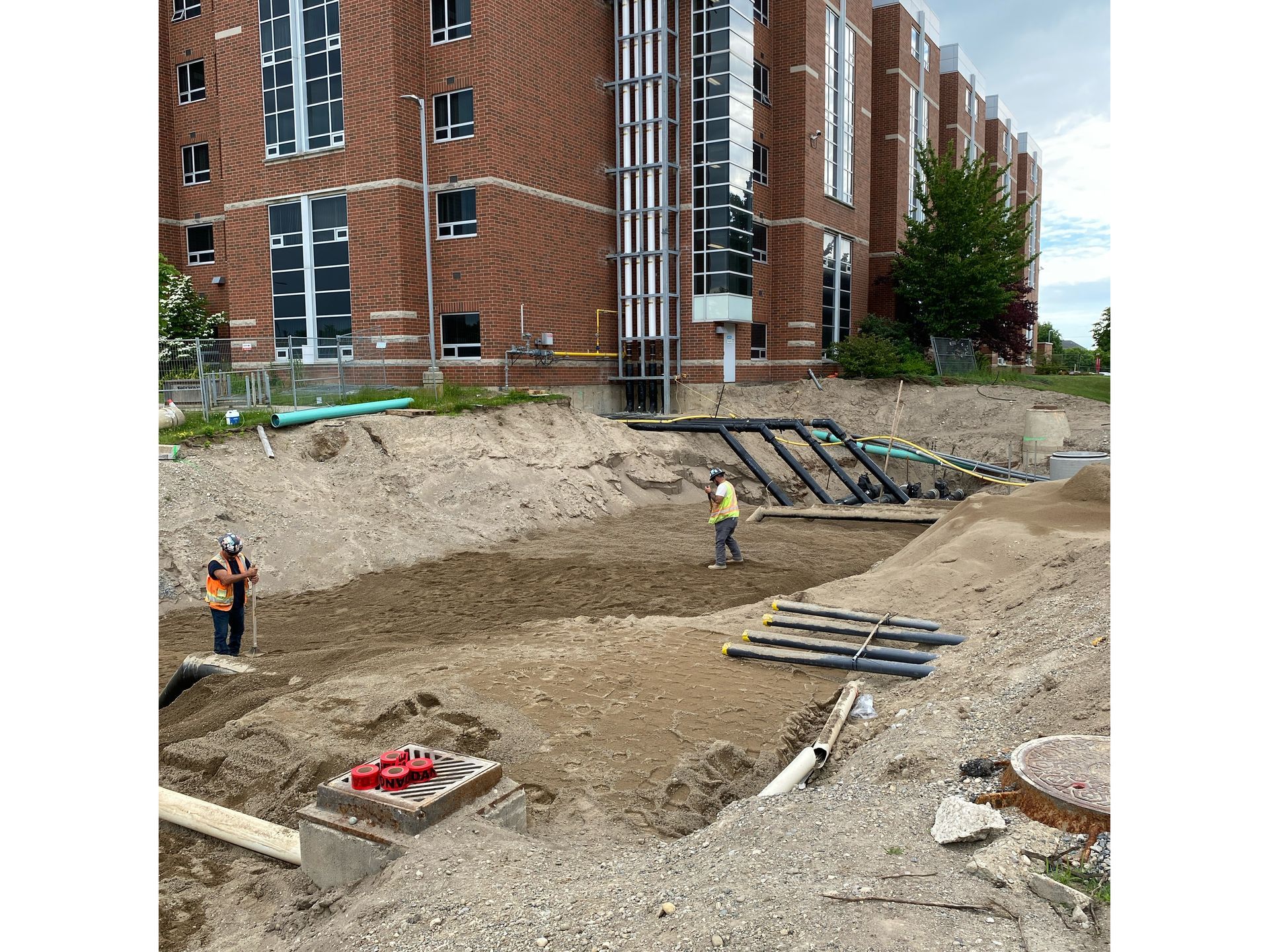 A construction site with a large brick building in the background.