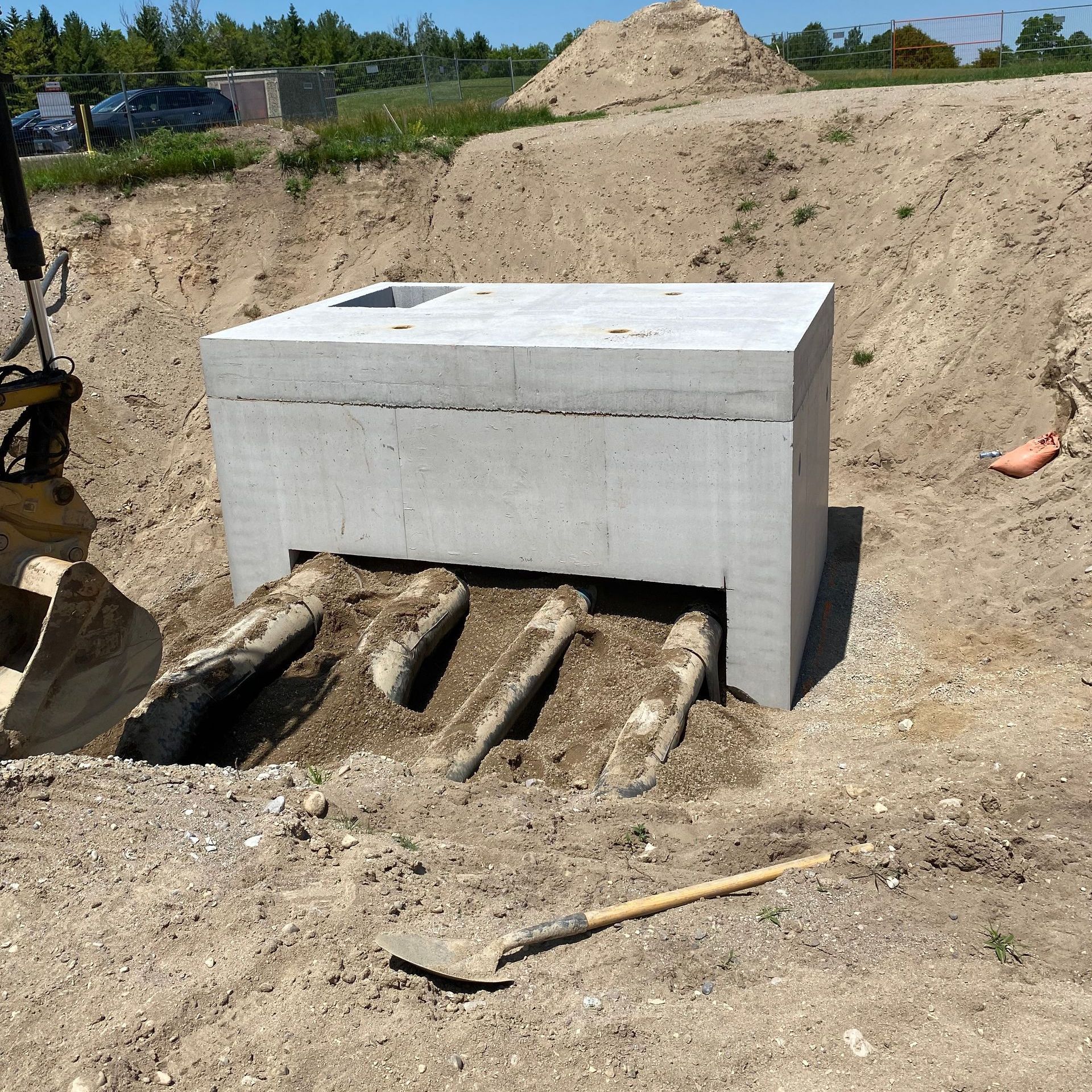 A concrete block is sitting in the dirt next to a shovel