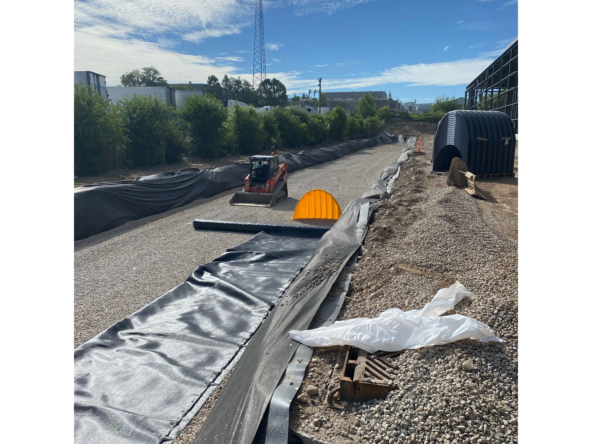 A tractor is driving down a gravel road.