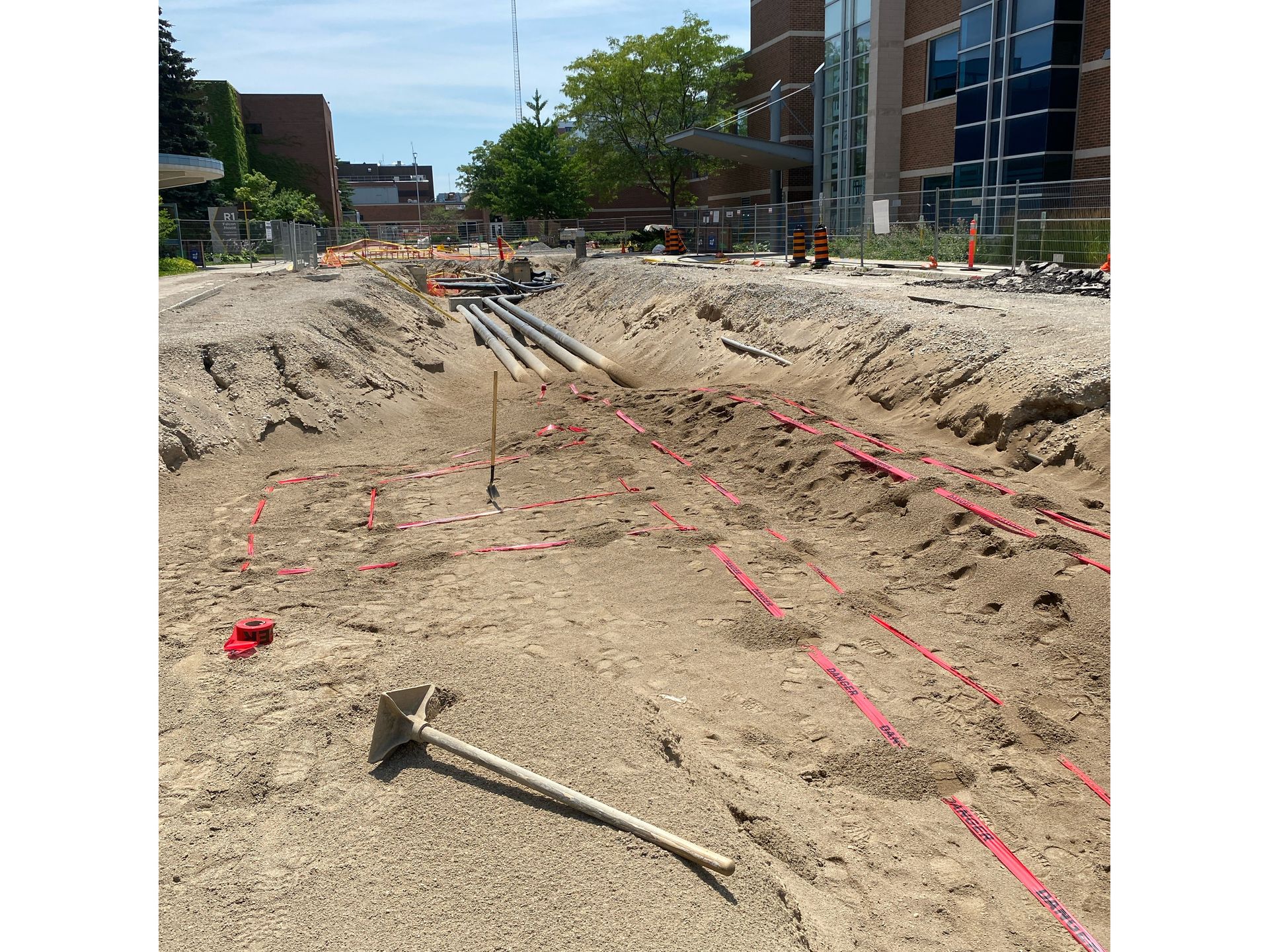 A shovel is laying in the dirt in a construction site.