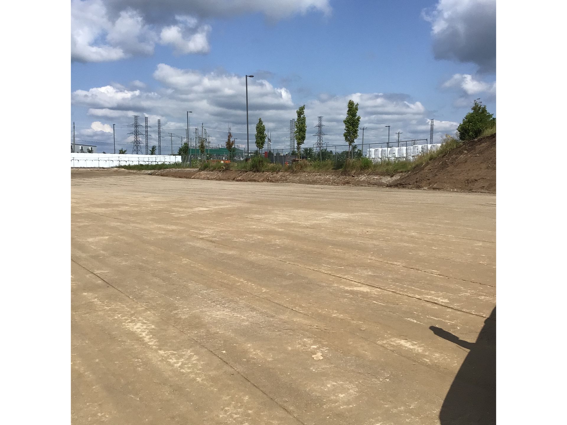 A large dirt field with a lot of trees in the background