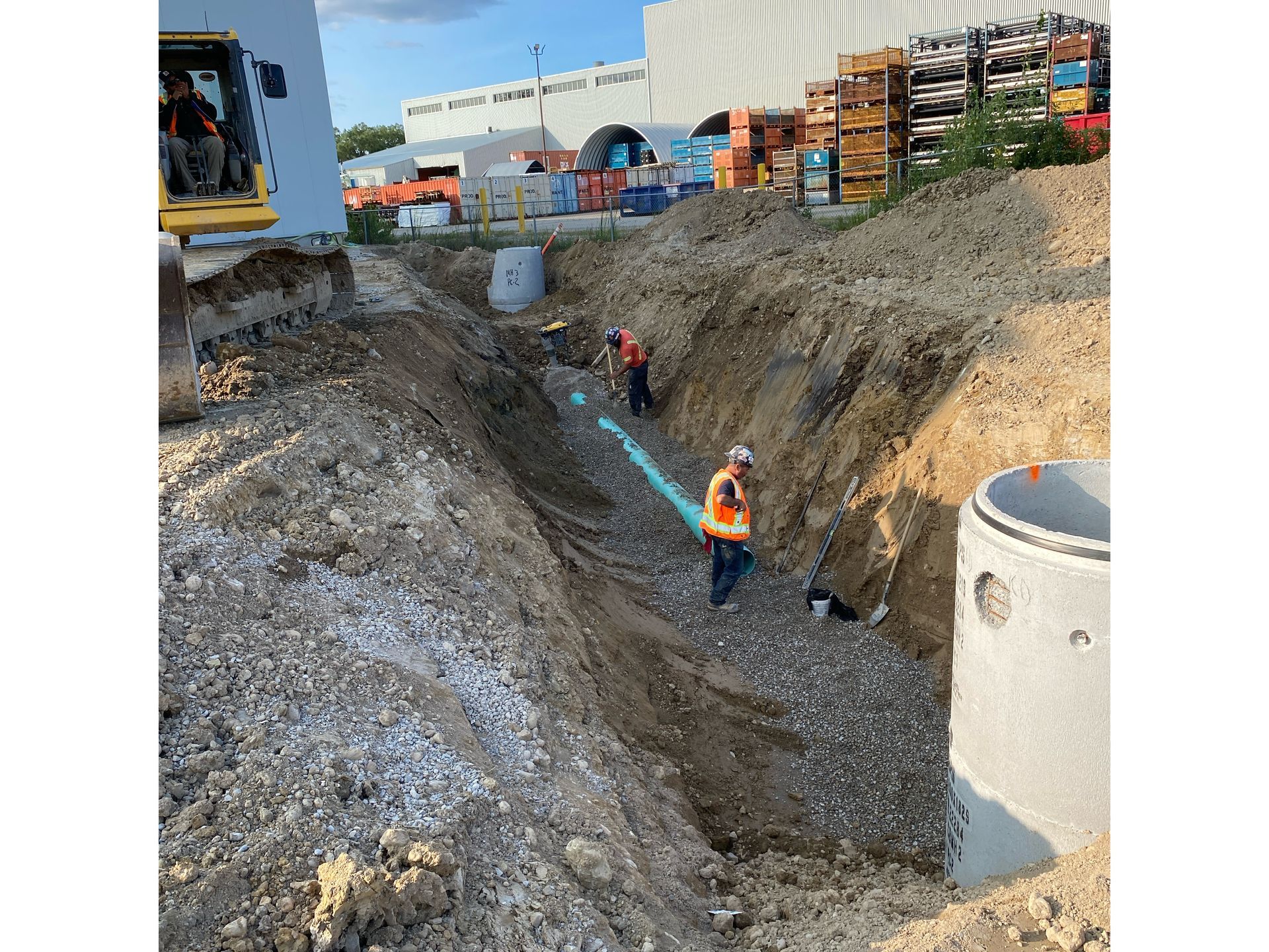 A group of construction workers are digging a trench in the dirt.