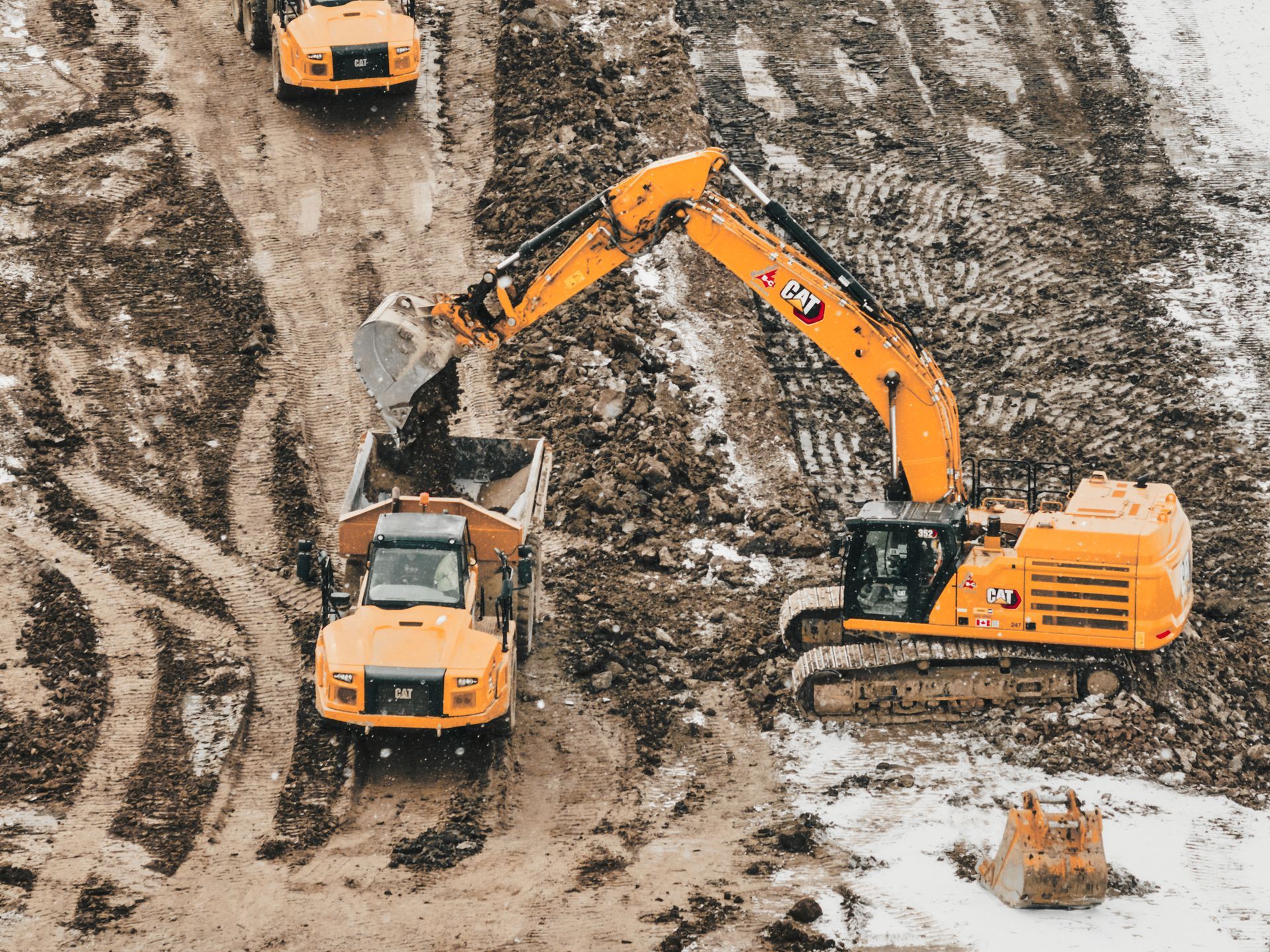 A group of construction vehicles are working on a dirt road  in St. Thomas