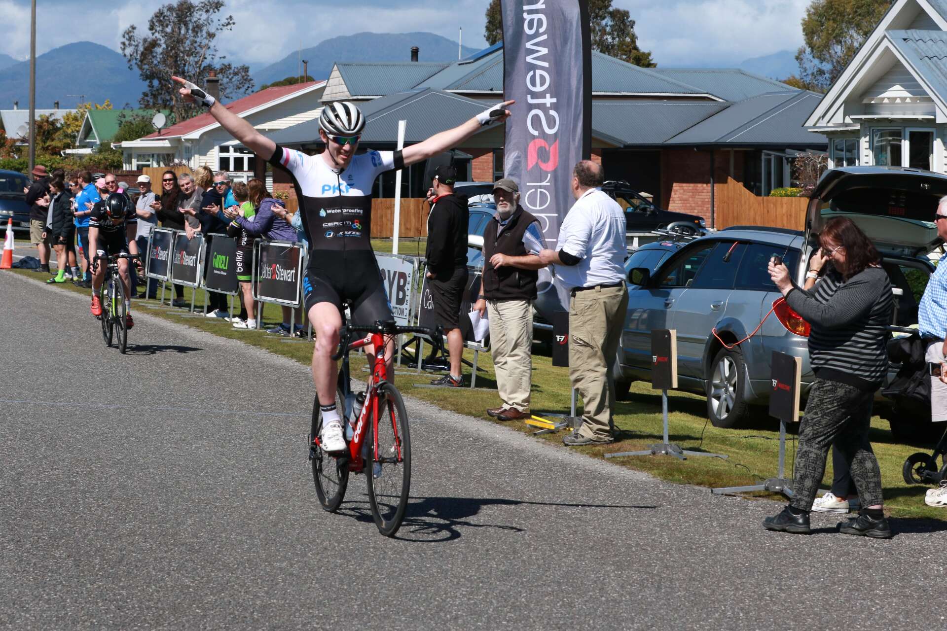 A man is riding a bike down a road with his arms in the air