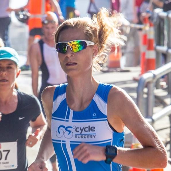 A woman wearing sunglasses and a blue shirt that says gs cycle surgery