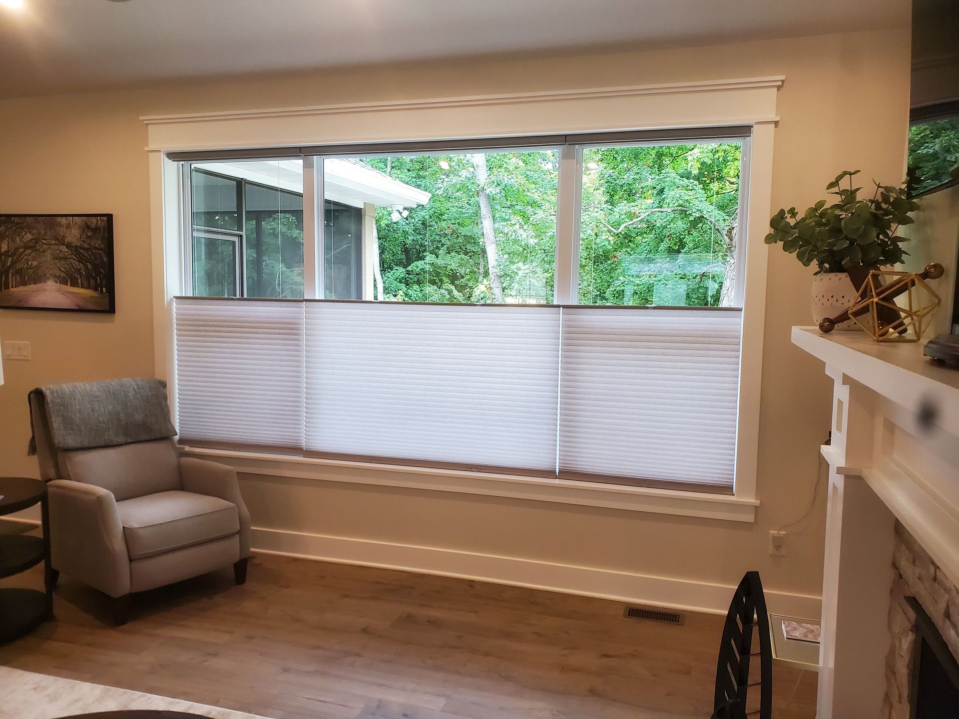 A living room with a large window , a chair and a fireplace. | East Peoria, IL | Blinds For Less