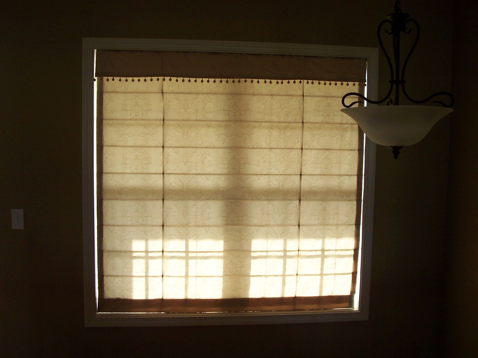 A window with a light hanging from the ceiling  — East Peoria, IL — Blinds For Less