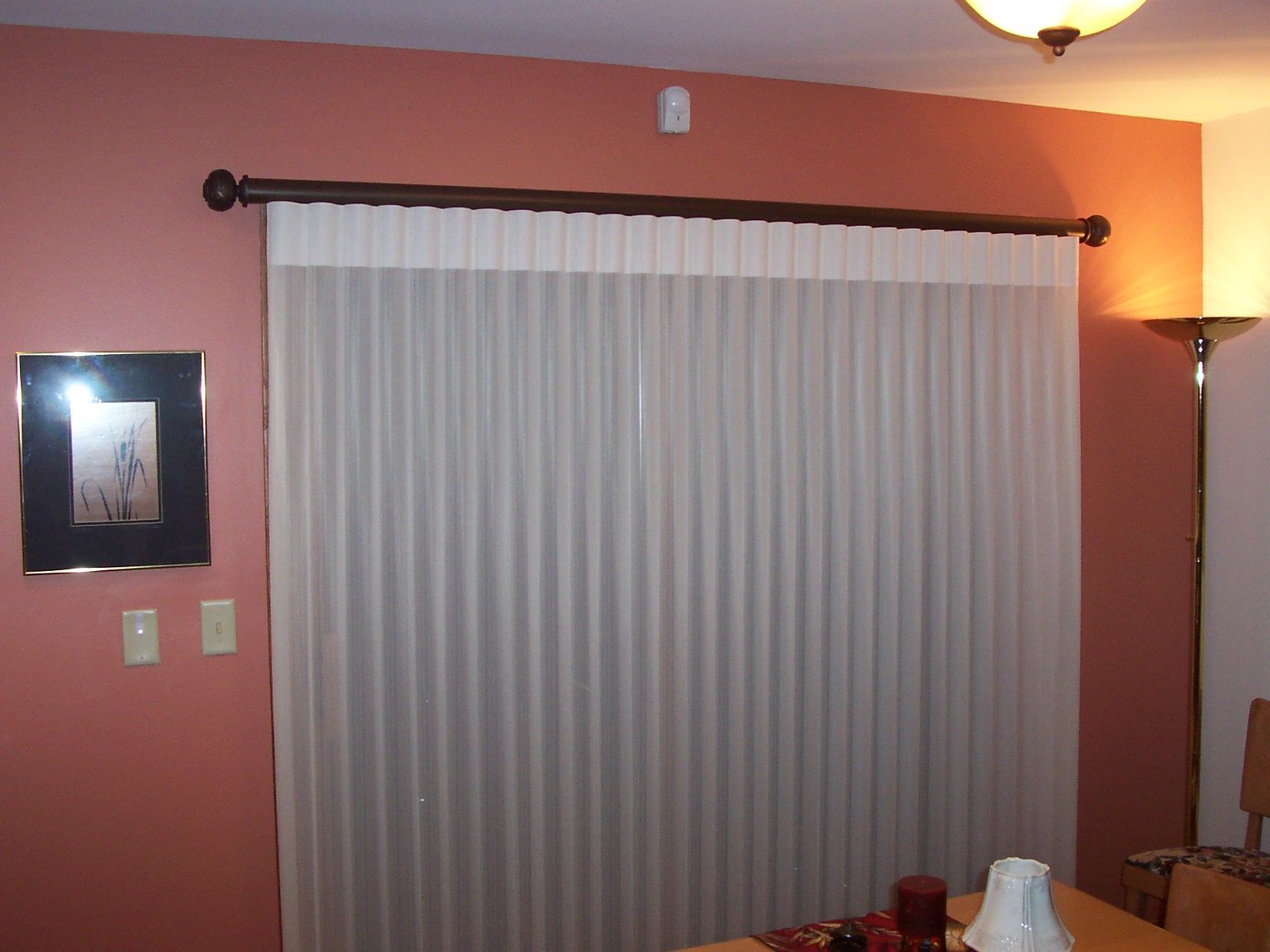 A dining room with a sliding glass door and white curtains  — East Peoria, IL — Blinds For Less