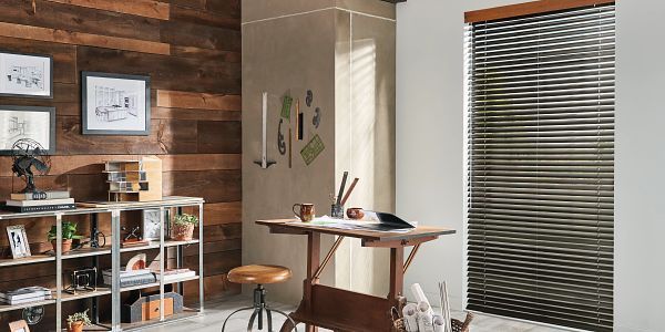 A room with a wooden wall , a desk , a shelf , and blinds.