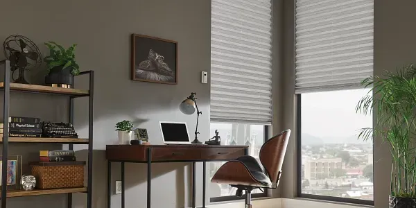 A home office with a desk , chair , laptop and window.