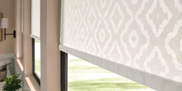 A roller blind with a pattern on it is hanging on a window in a living room.