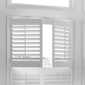 A white window with white shutters on it.