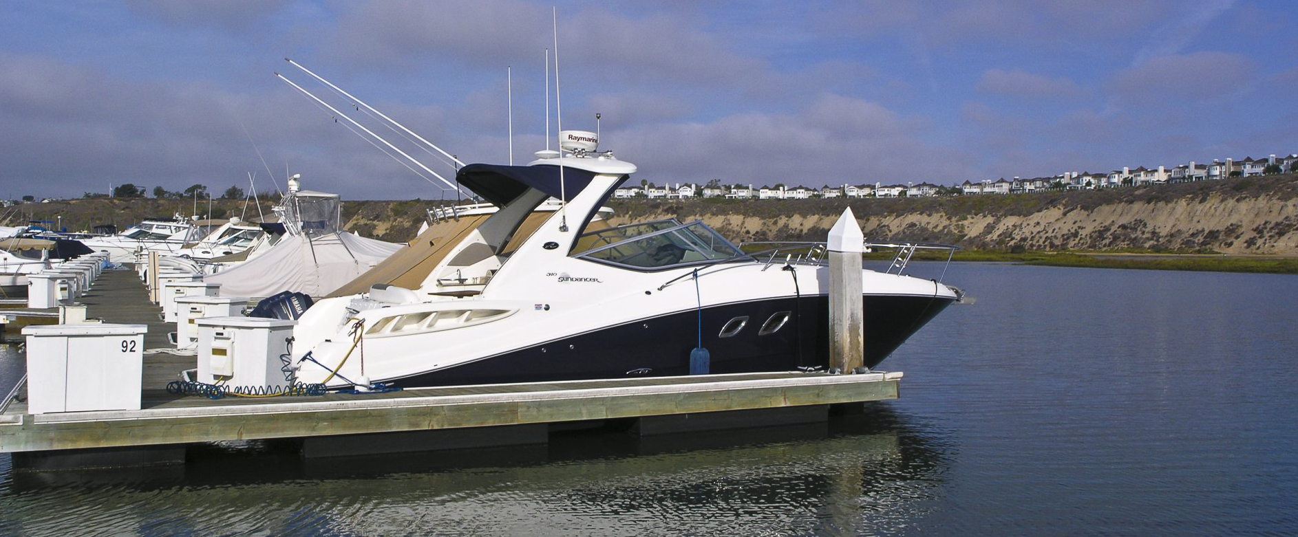 Boats Slipped in Bayside Marina with View of the Channel and Homes on Bluffs in Background
