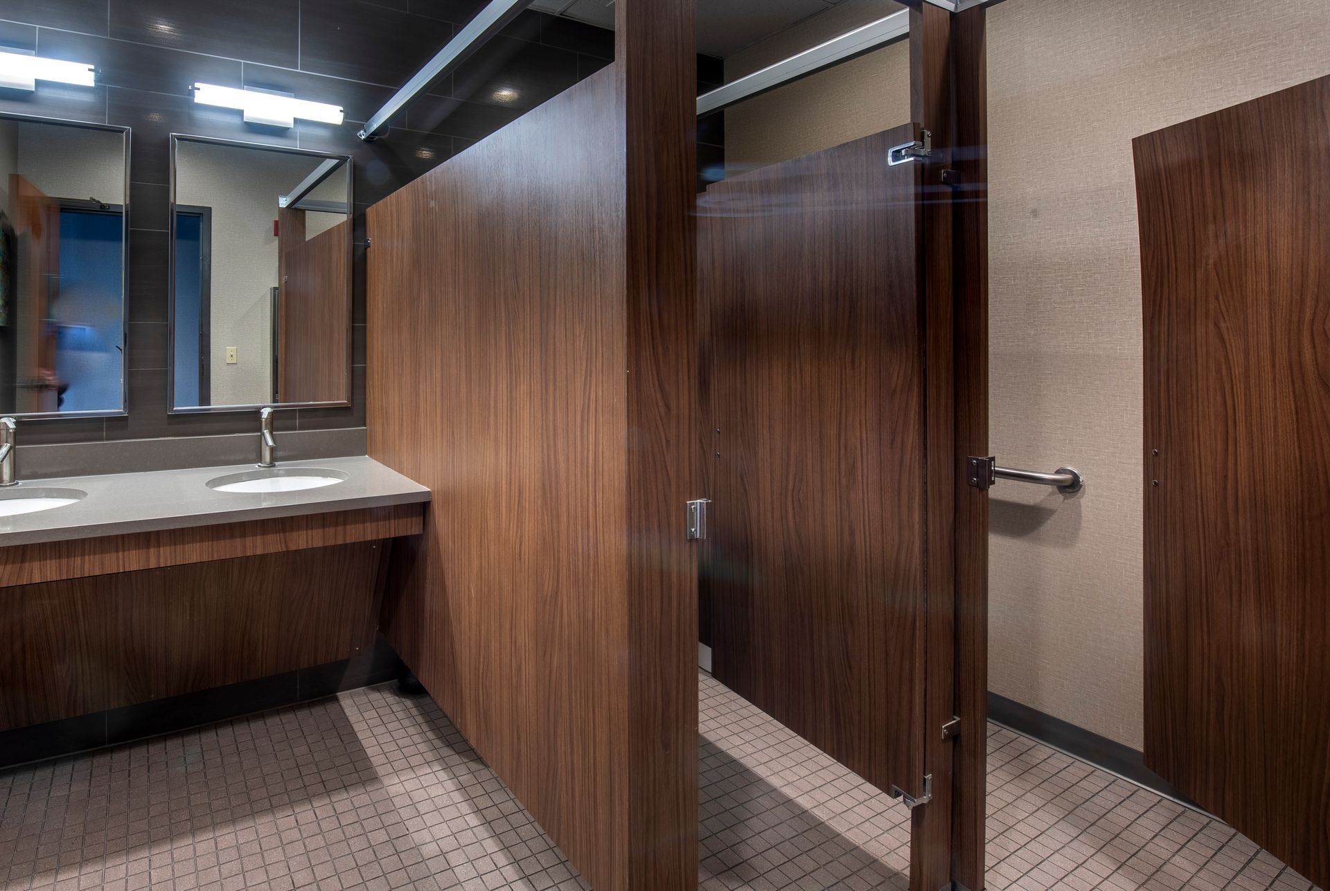 A bathroom with wooden dividers and two sinks.