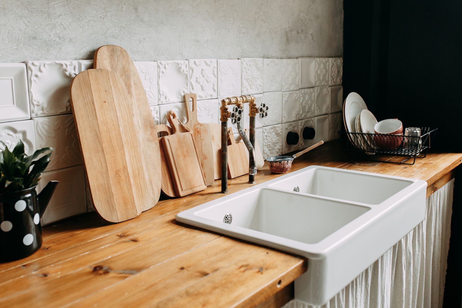 A kitchen with a double sink and wooden counter tops.