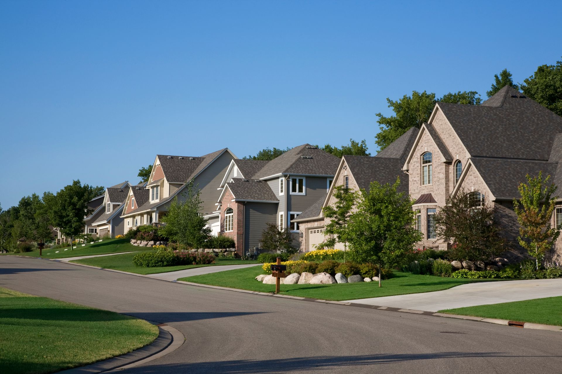 A row of houses on a residential street with a mailbox in the middle