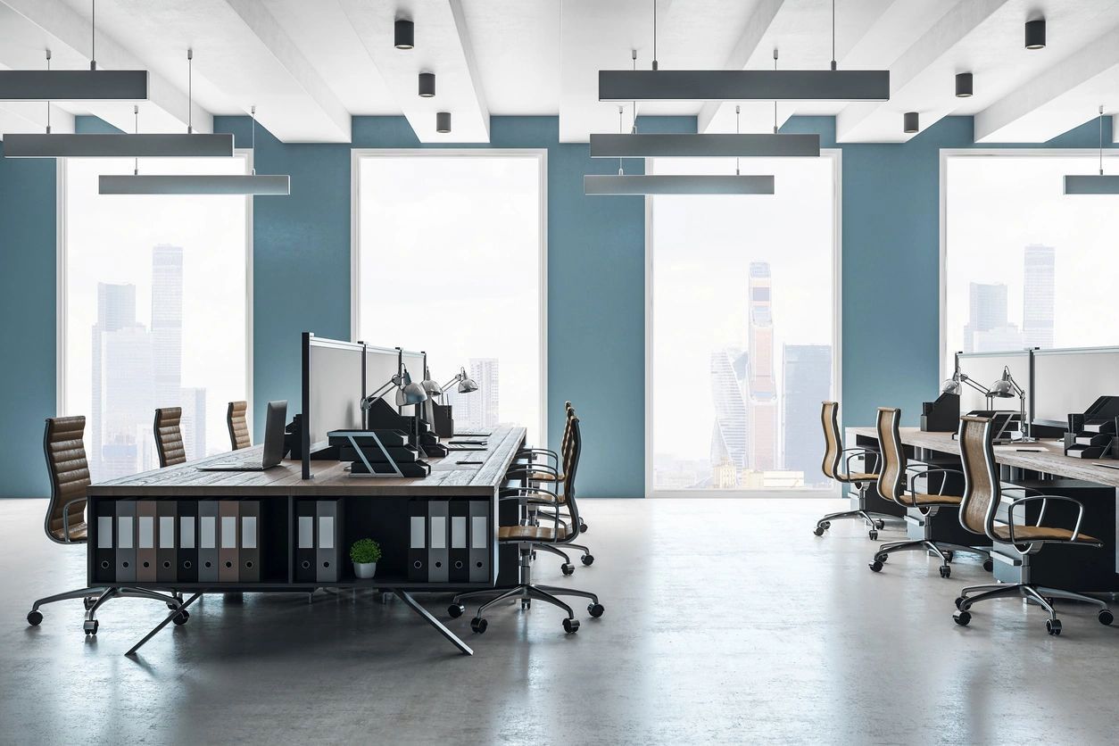 An empty office with a lot of windows and tables and chairs.