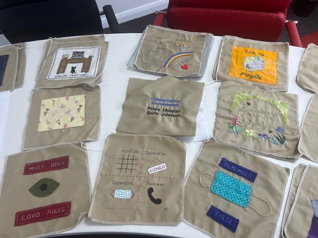 An array of squares on beige for the Covid Quilt Project