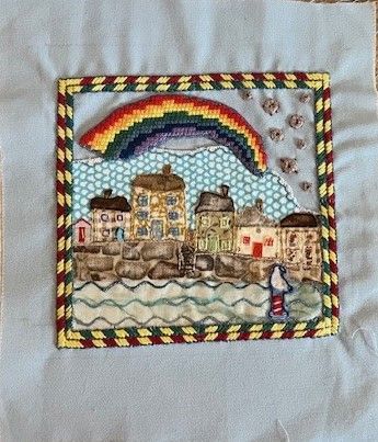 One of the embroidered squares depicting an image of times during Covid embroidered on scrub fabric