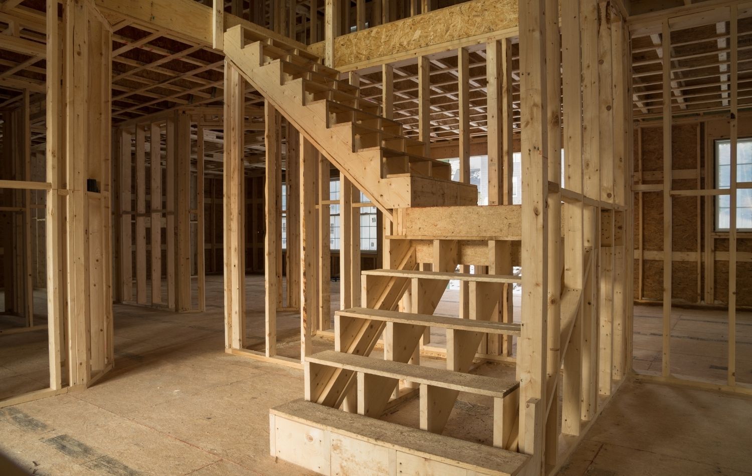 White house with dark blue ground floor, porch, and blue sky.