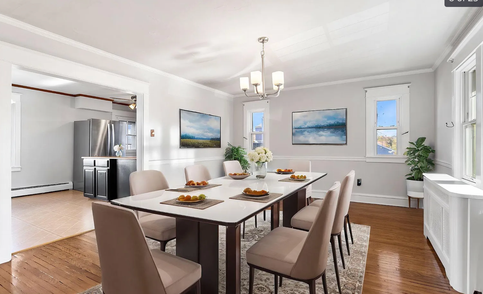 Dining room with table, chairs, art, and doorway to a kitchen.