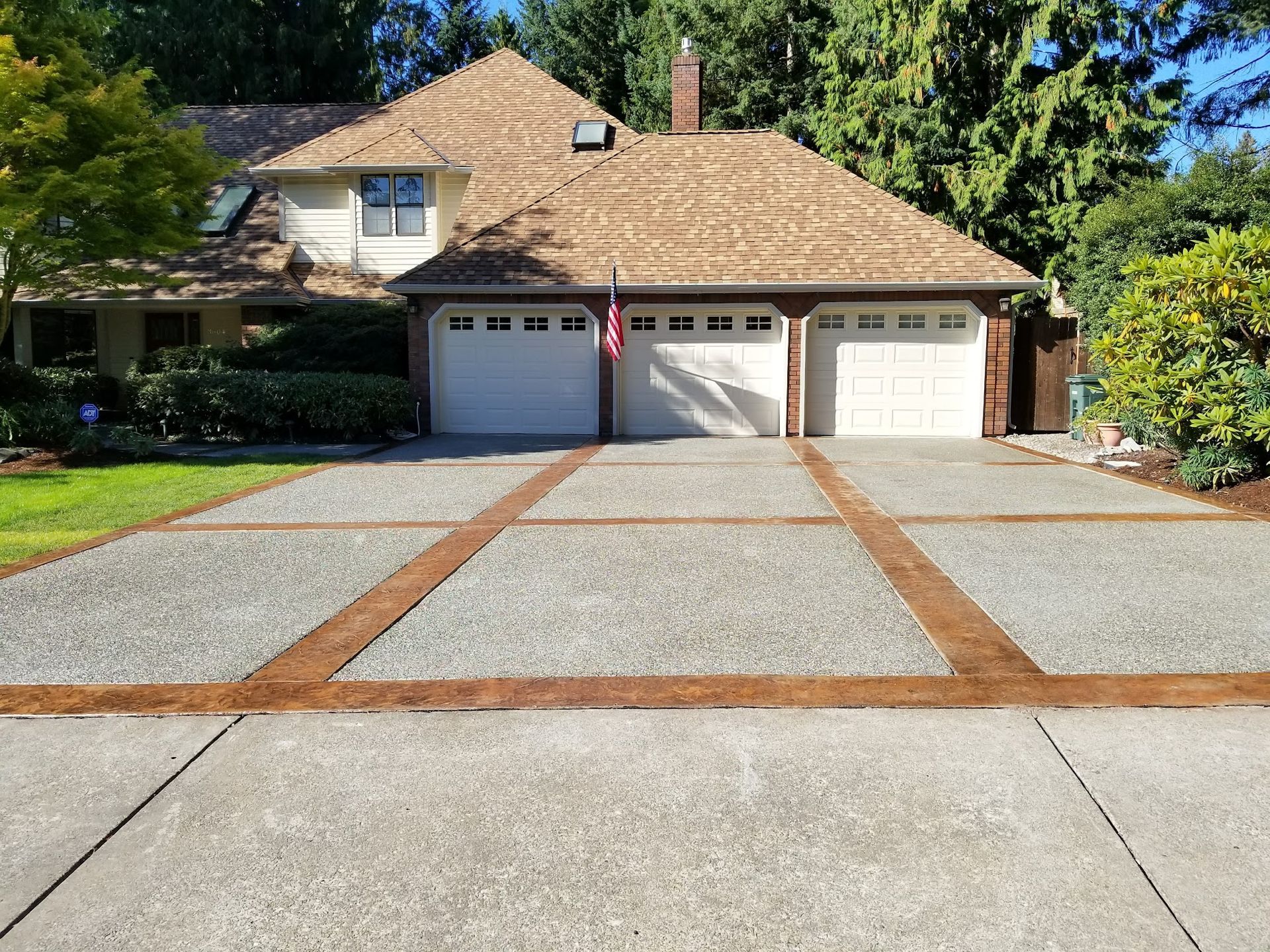 A driveway leading to a house with two garage doors