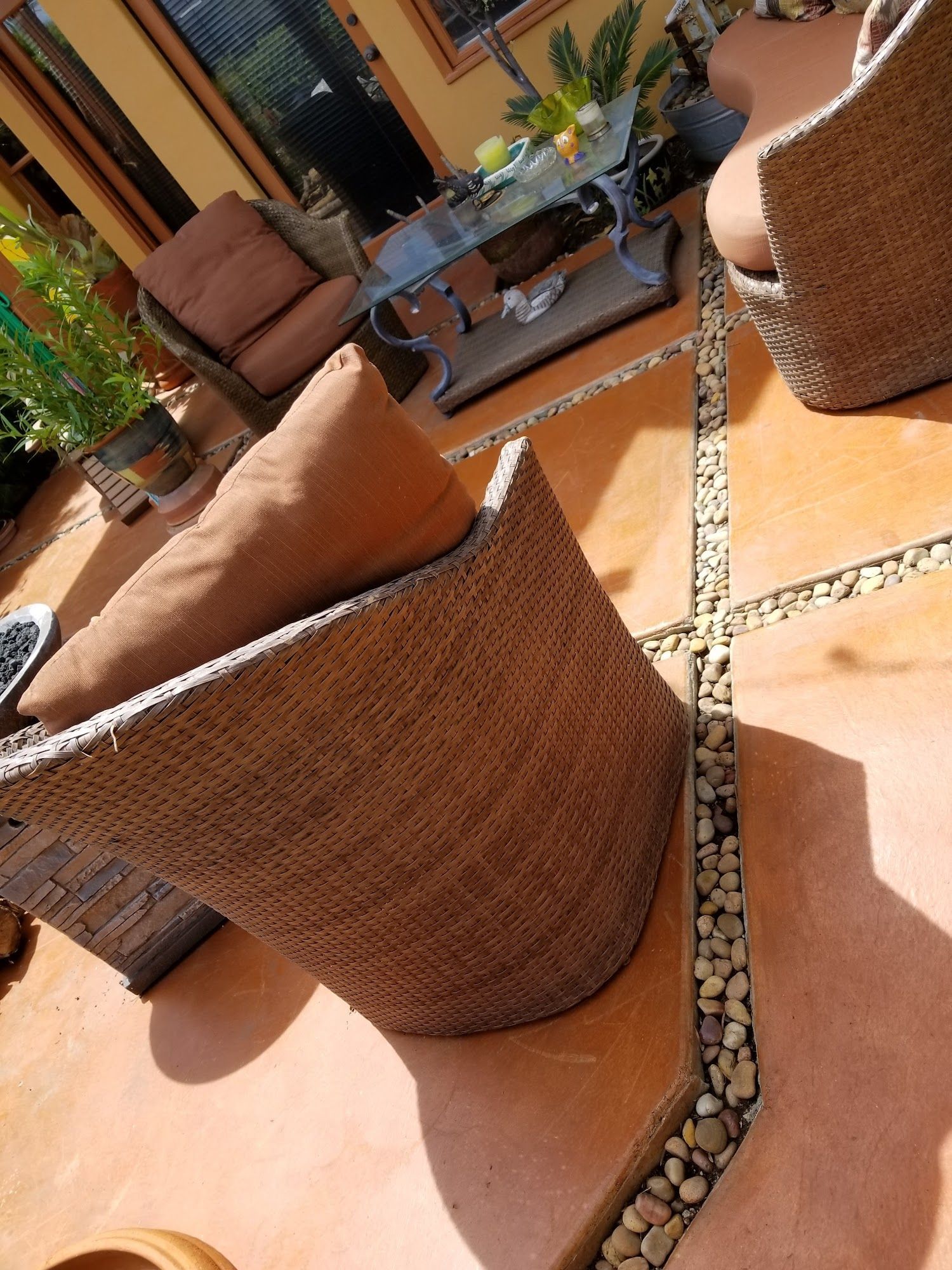 A patio with wicker chairs and a coffee table