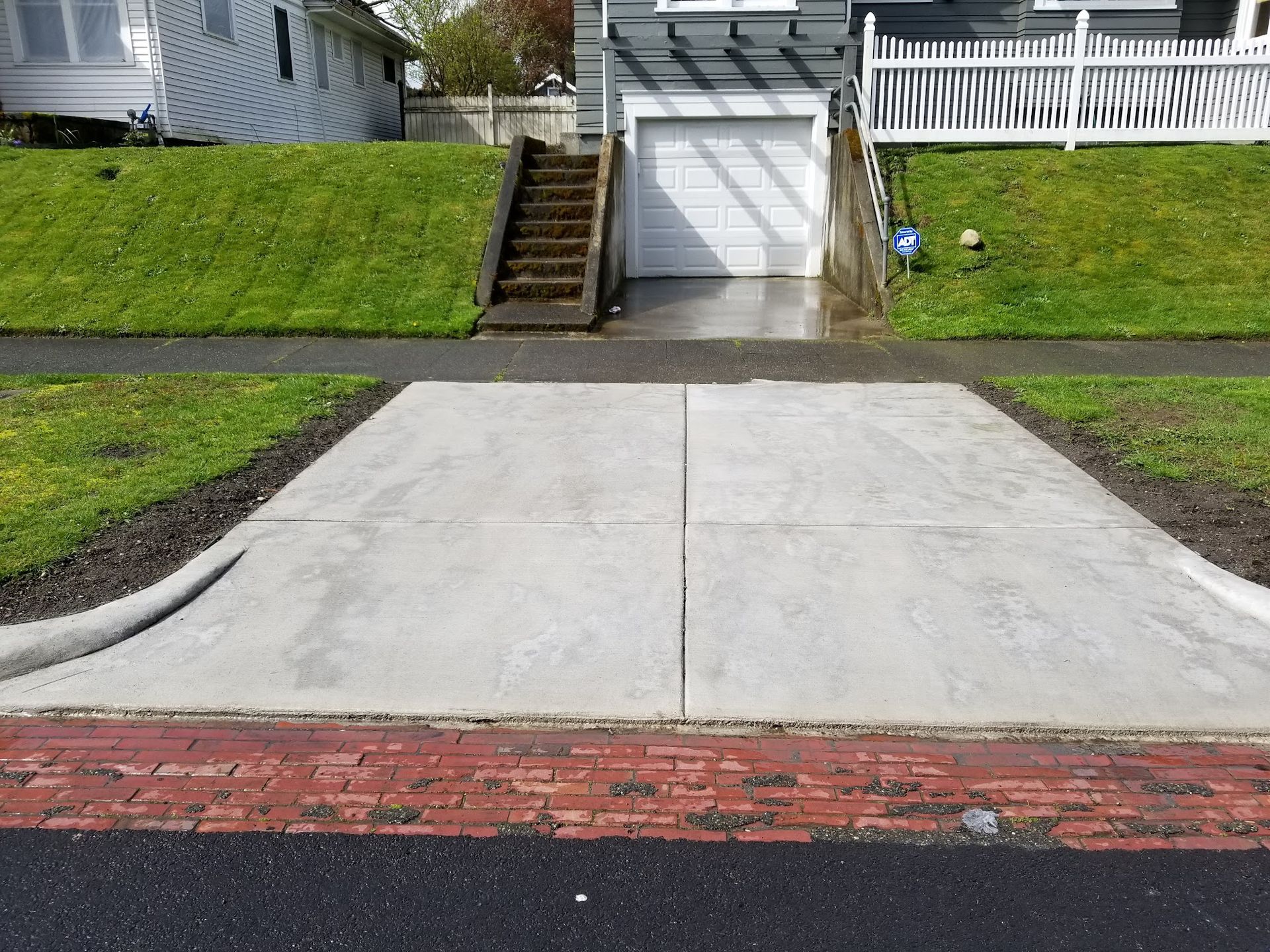 A driveway leading to a garage with stairs leading up to it
