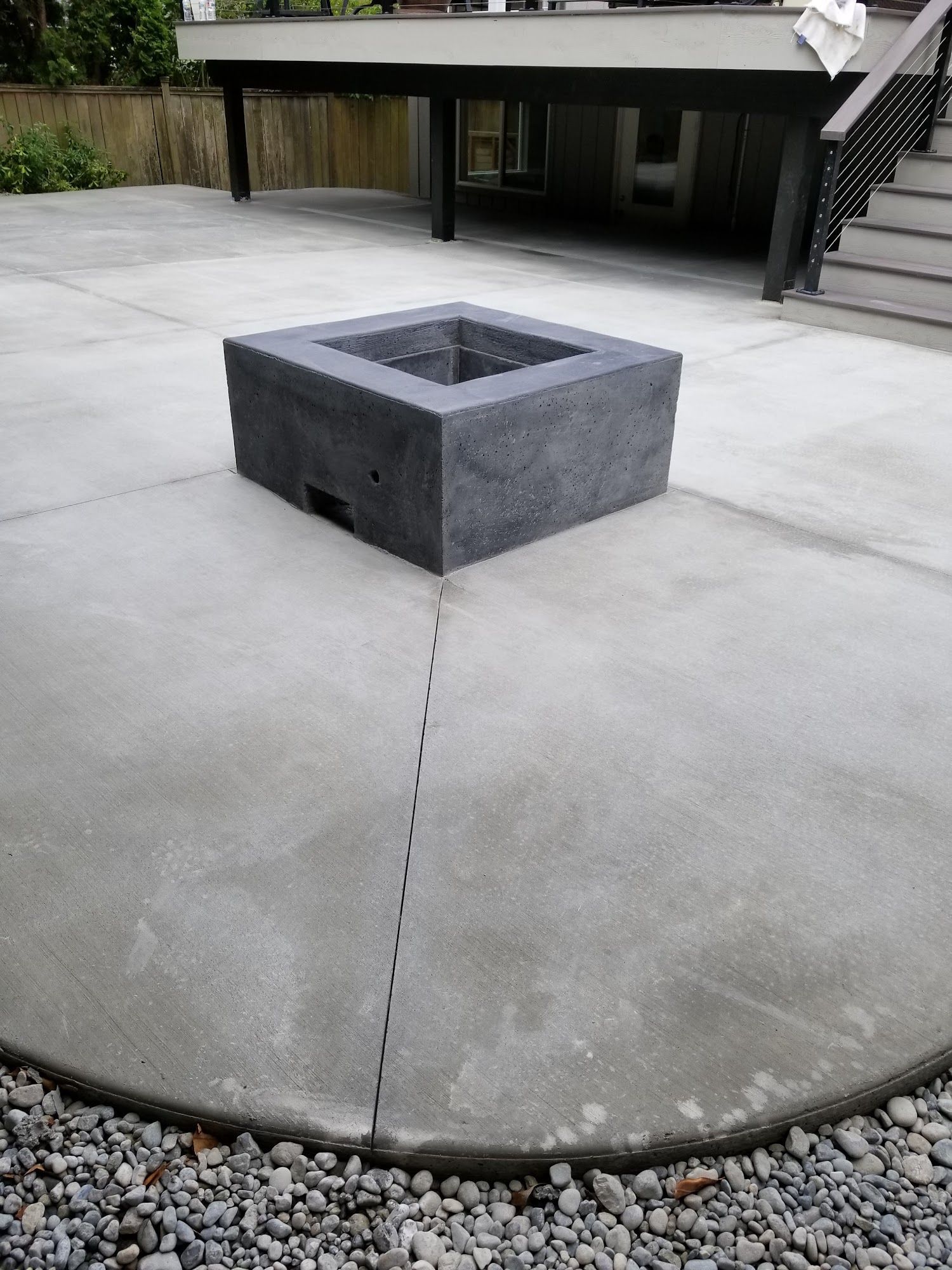 A concrete patio with a fire pit in the middle