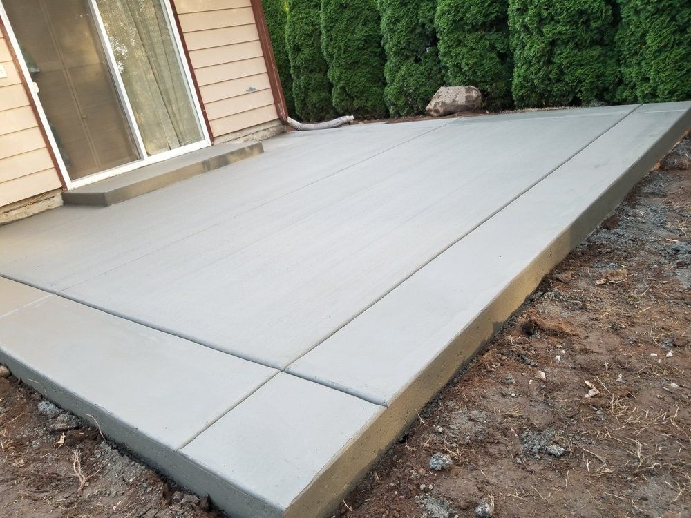 A concrete patio is being built in front of a house.