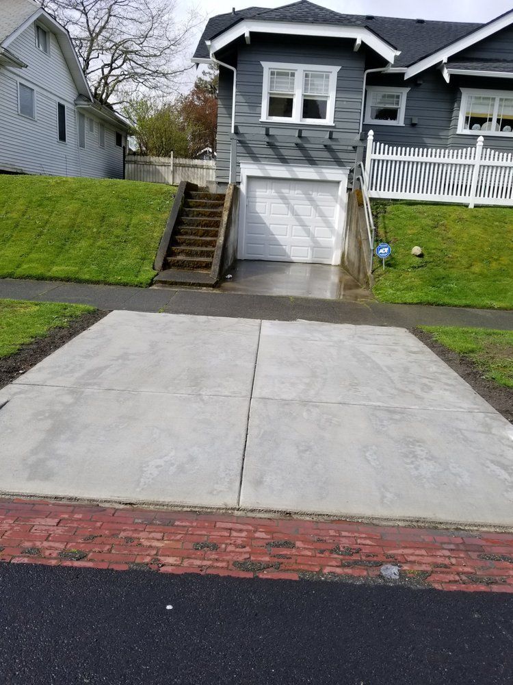 There is a concrete driveway in front of a house.