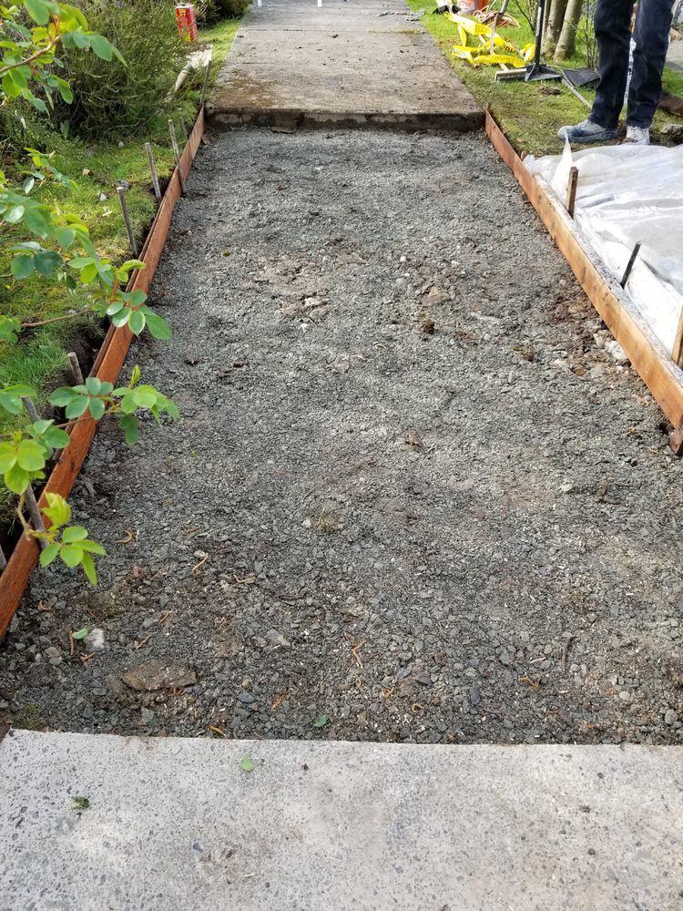 A gravel path is being built next to a sidewalk.