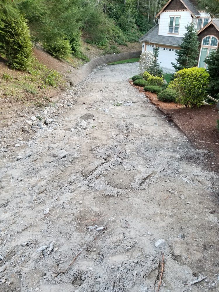 A dirt road leading to a house on a hill.