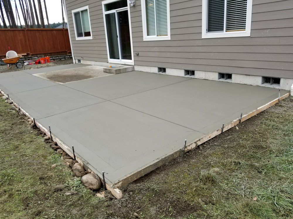 A concrete patio is being built in front of a house.