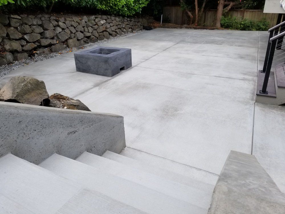 A concrete patio with stairs and a fire pit