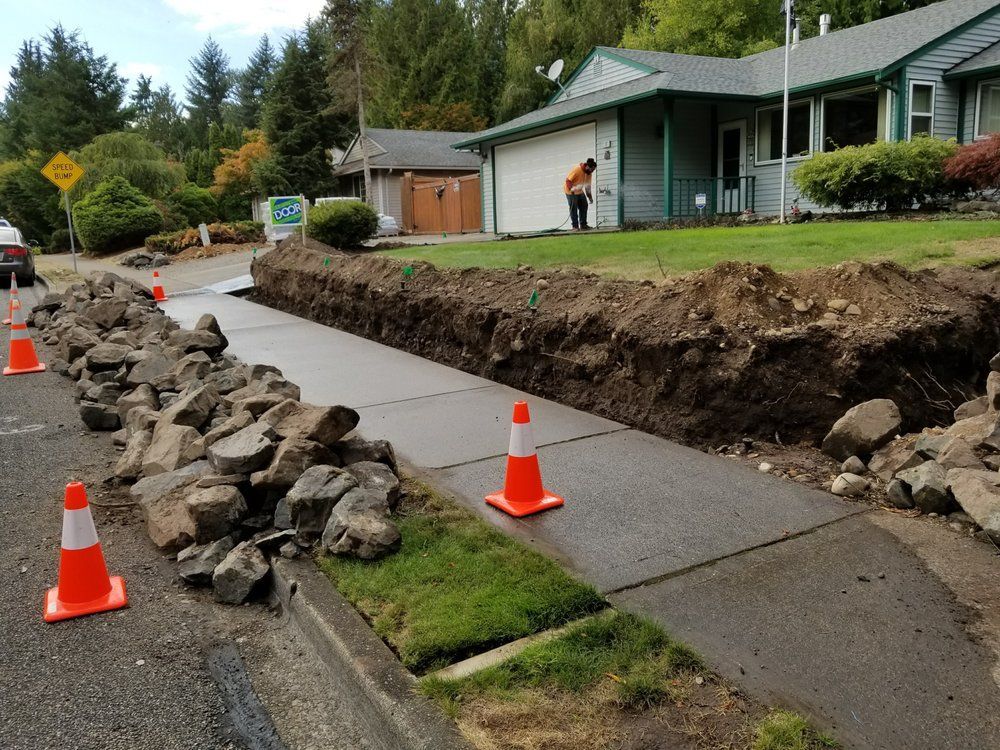 A man is working on a sidewalk next to a house