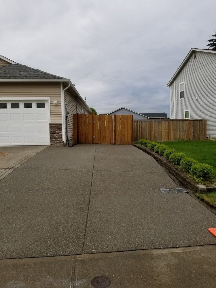 A driveway leading to a house with a wooden gate.