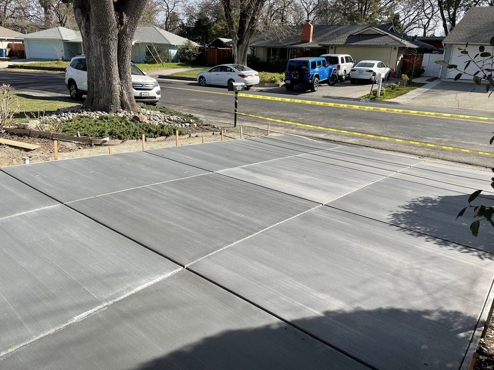 A concrete driveway is being built in a residential neighborhood.