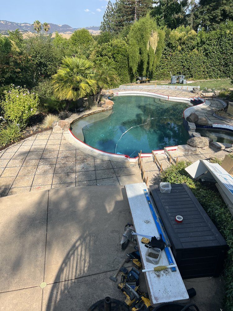 A large swimming pool is being built in a backyard.