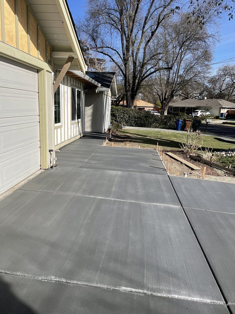 A concrete driveway is being built in front of a house.