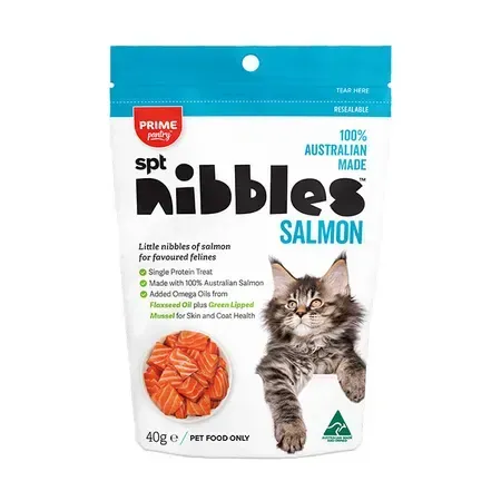 A bag of "spt nibbles salmon" cat treats, with a cat, salmon pieces, and text on a white and blue background.