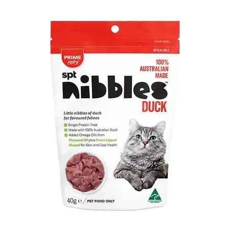 Bag of "spt nibbles" duck cat treats with a picture of a cat, featuring red and green accents, and a bowl of duck pieces.