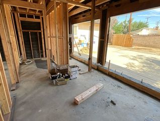 Interior of a building under construction, showing wooden frames and a concrete floor.