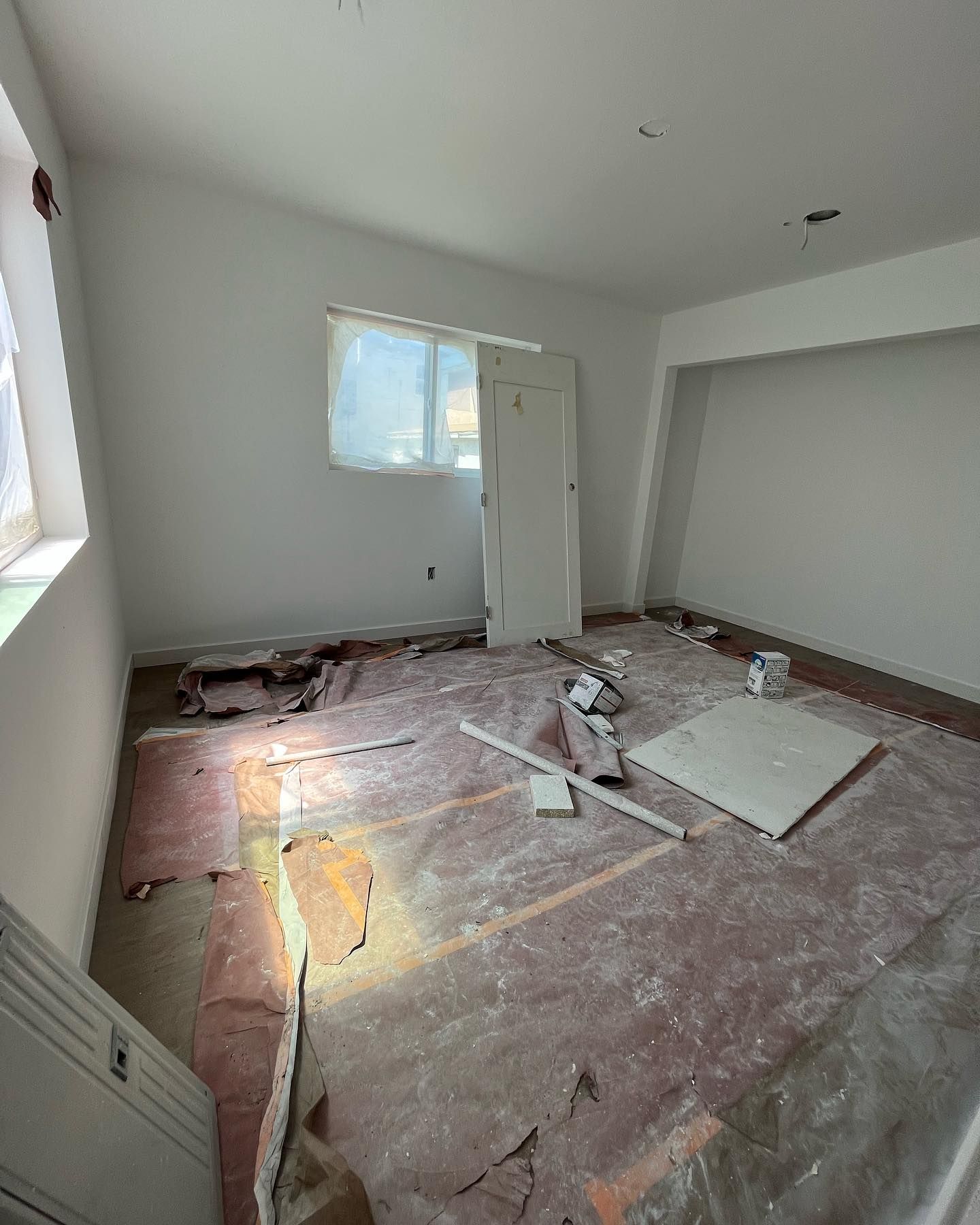 Room under construction, exposed flooring, bare walls, unfinished door, and window.