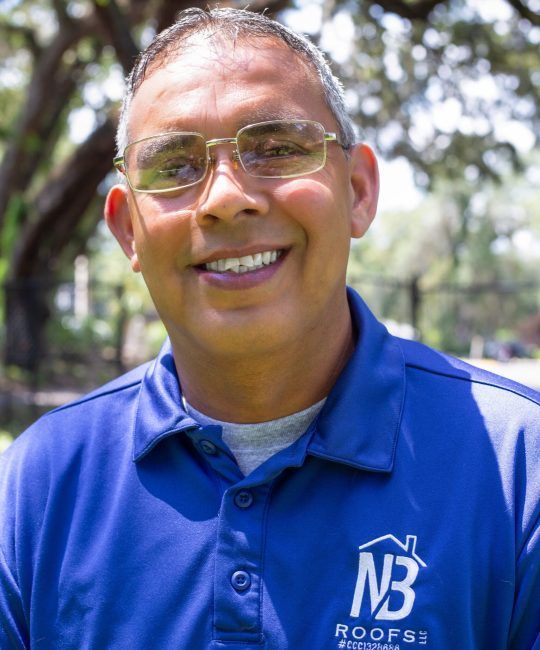 One of our team  Carlos Nieves, wearing glasses and a blue shirt with Nieves & Baker Roofing logo
