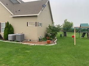 There is a swing set in the backyard of a house.