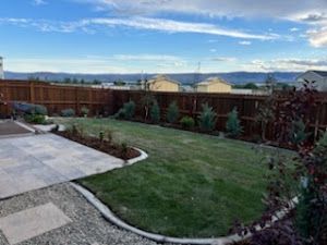 A backyard with a wooden fence and a patio.