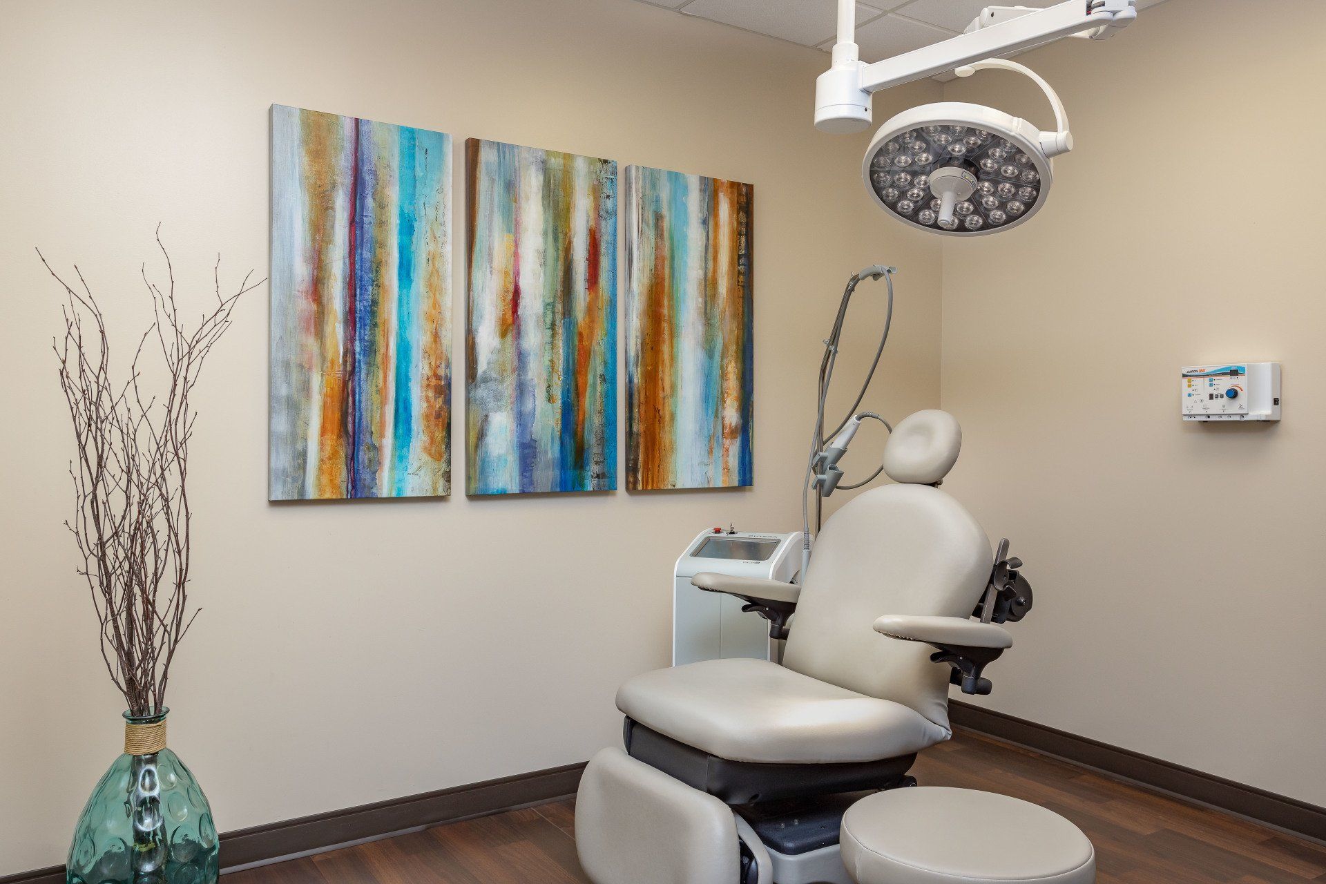 A surgery room with a surgical chair and paintings on the wall.