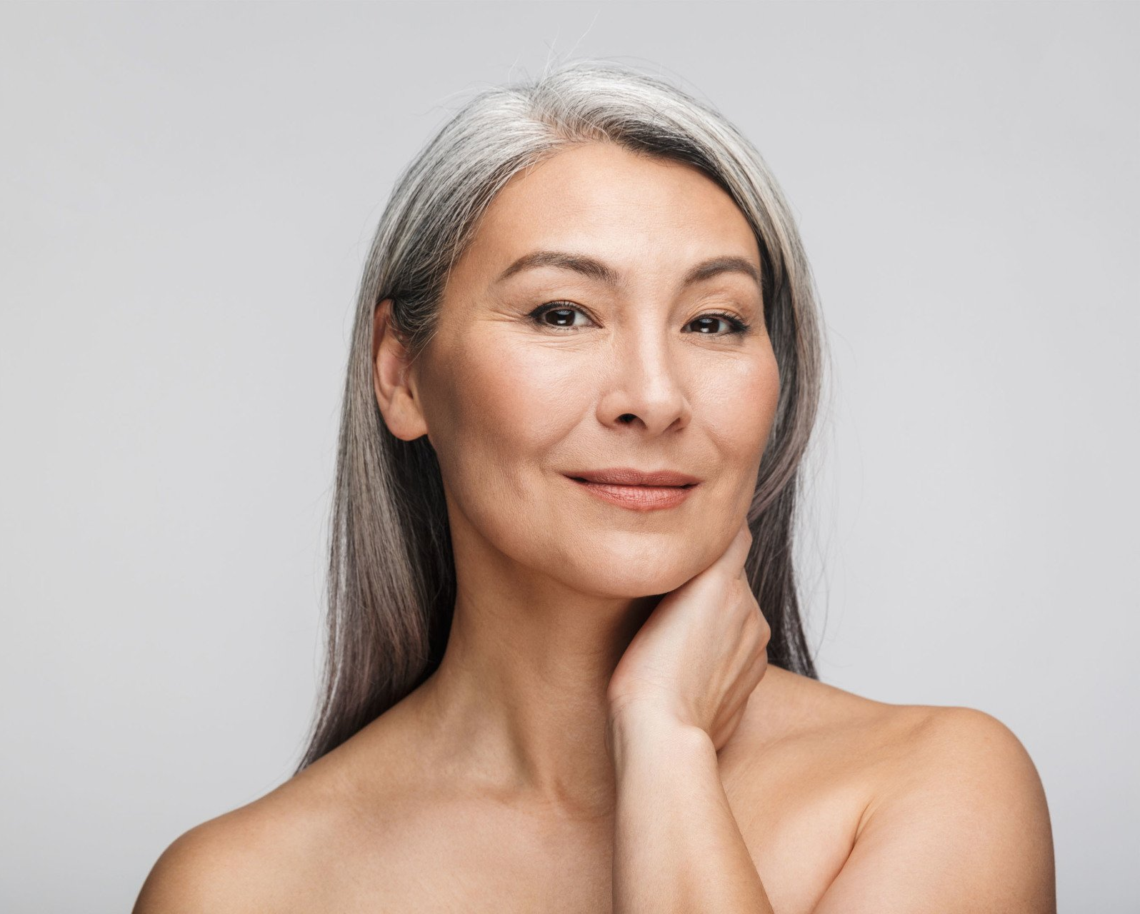 pretty, mature asian woman after cosmetic dermatology treatments